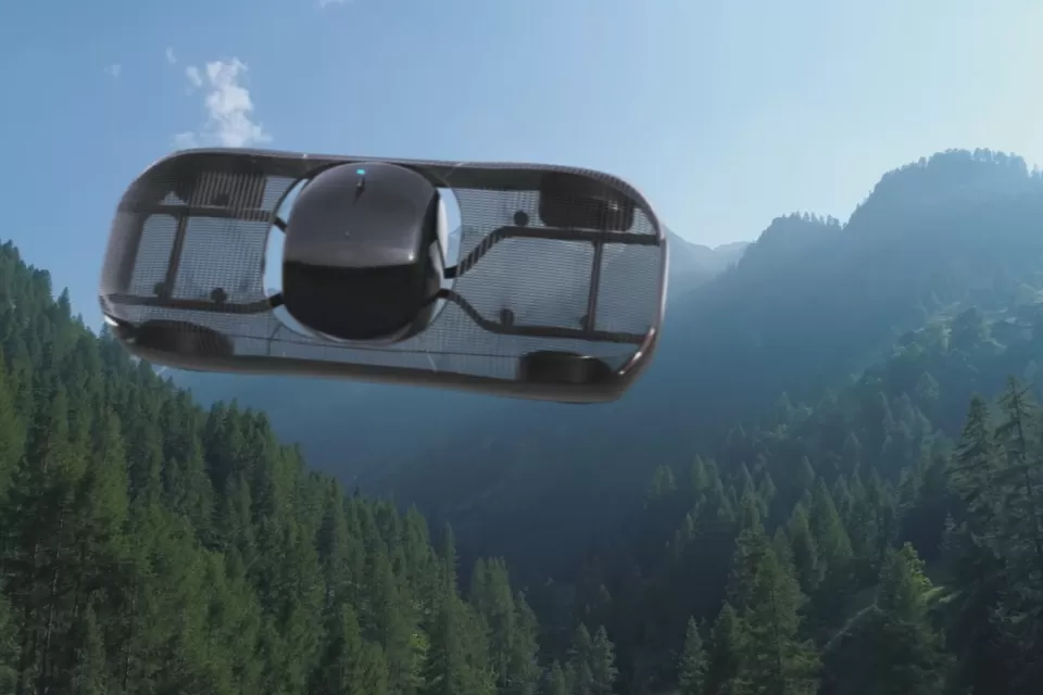 A conceptual rendering of a flying car, pictured in flight over mountains.